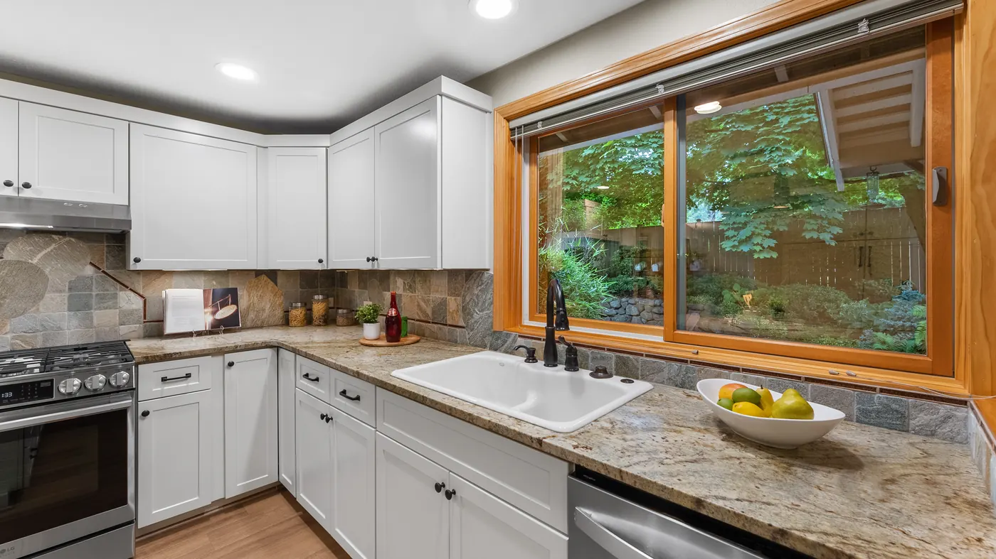 Bright kitchen with white cabinets, an island and a garden window
