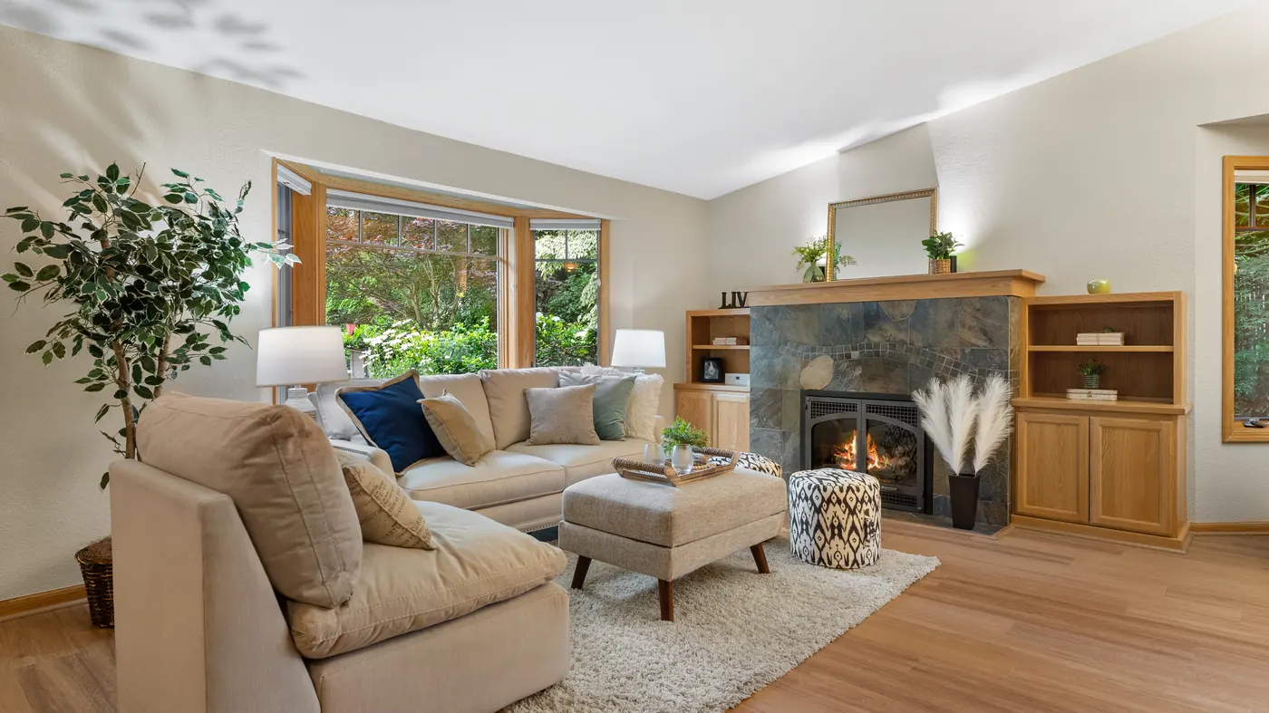 Staged living room with a stone fireplace and built-in shelves
