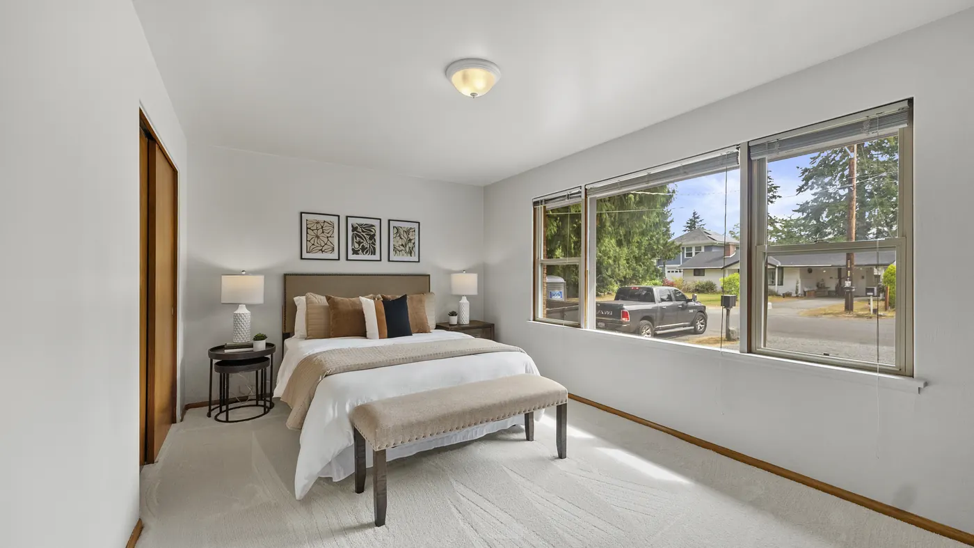 Staged bedroom with a large window onto trees