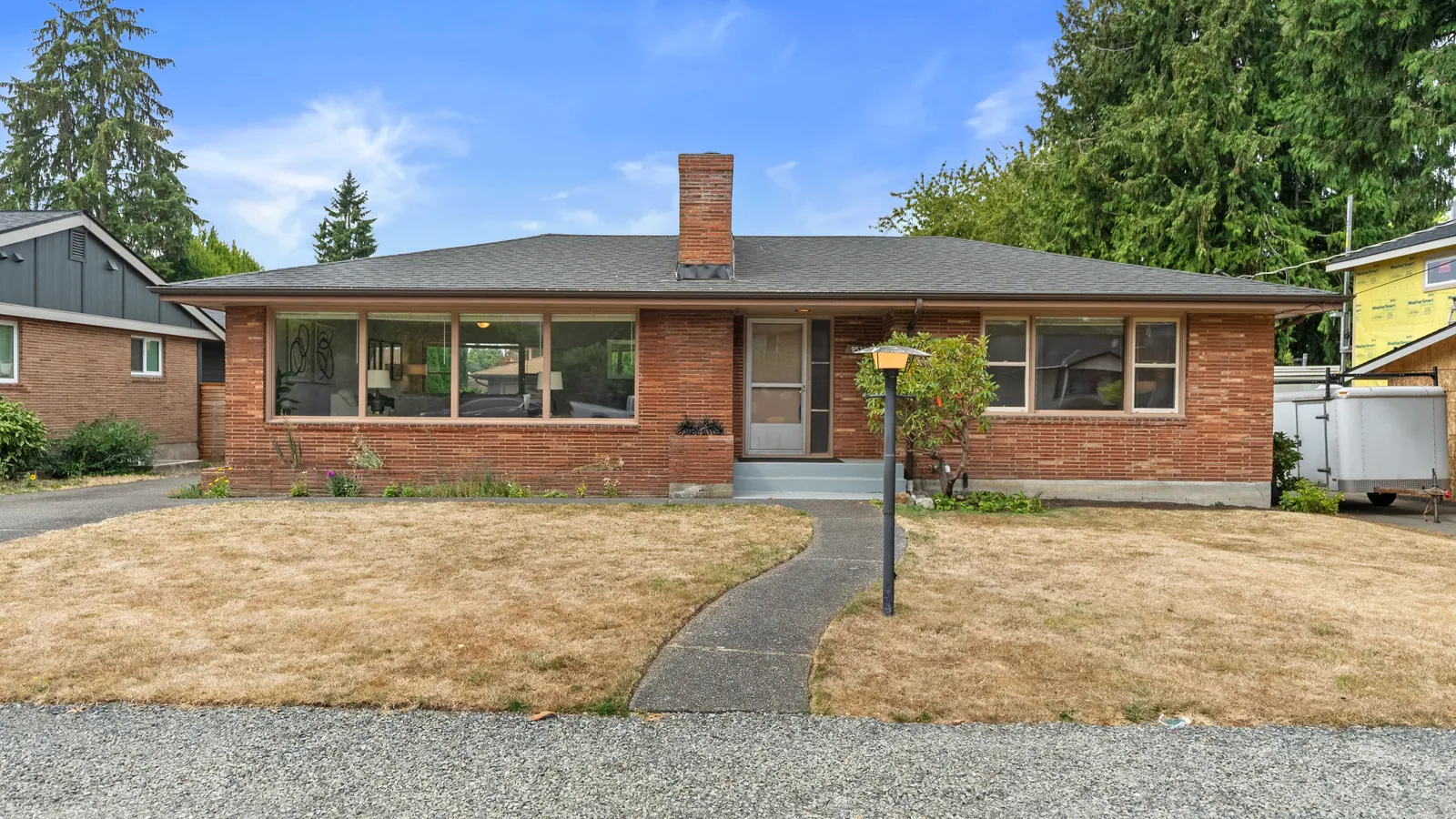 Brick mid-century rambler with a wide front lawn in northwest Seattle